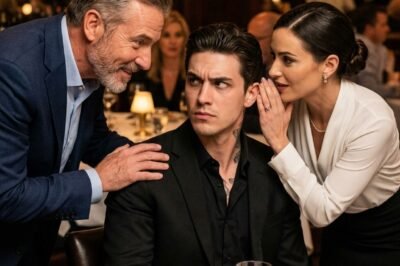 “Look Under Your Table.” The Waitress Desperately Warned The Mafia Boss — Seconds To a Hidden Trap By the time anyone thought to look for a cause, the gel would be gone. The table would be wiped clean. Ravi Zoric’s death would be filed under heart failure. arrow_forward_iosWatch More Pause 00:00 00:02 04:45 Mute Natural causes. Mirea thought about walking to one of Ravi’s security men near the door. She imagined herself doing it. Walking. Speaking. Handing over her fear like a note that would be read and understood. She thought about it for four seconds and abandoned it. Sandro’s men were closer to Ravi than Ravi’s own. She had noticed it earlier, the way chairs had been arranged, the way bodies occupied space. Sandro had maneuvered it. His people were positioned between Ravi and the exits, between Ravi and his own staff, between Ravi and every route that wasn’t the one Sandro controlled. If she approached the wrong man, she would be escorted out the back and the dinner would continue exactly as planned. She thought about saying nothing. She could finish her shift. She could go home. She could tell herself she wasn’t sure. That she might be wrong. That it wasn’t her business. That powerful men like Ravi Zoric made enemies for reasons she would never understand, and that wasn’t her fault. She could sleep tonight and find out tomorrow that a famous criminal had died at the port and think about Tomas in his hospital bed and know for the rest of her life that she had been three feet away and said nothing. Then another thought arrived, quiet and sharp. Bernard. The other servers. The dishwasher who’d been asked to stay late. If Ravi died here, this place would become a crime scene. Questions would come like knives. The staff would be the first to bleed. The ones who served the food, poured the wine, handled everything near that table. People with no protection. No money for lawyers. No way to prove they hadn’t known. It was one thing to let a storm take down a ship you didn’t care about. It was another thing to let the storm drown the people still on deck. Mirea picked up the wine bottle and walked back into the dining room. The two men were laughing at something. Sandro’s hand lay flat on the table as he told a story with the enthusiasm of a man who had already won. Ravi listened with only half his attention. The other half was somewhere calm and distant, the way a chess player looks when he’s already four moves ahead and is only waiting for the other person to step where they’re supposed to step. Ravi’s right hand rested near the edge of the table, a centimeter from the gel. Mirea moved around the far side and came to Ravi’s right, leaning at the precise angle of a waitress adjusting a glass. Her hand was steady. She would think about that later too, how her body became a tool when she needed it, as if it understood the stakes and refused to shake. She reached for his wine glass, tilted it slightly, and leaned close enough that her words would go nowhere except into the six inches of air between her mouth and his ear. She didn’t move her lips more than necessary. “Sir,” she said. “Look under the table. Don’t touch it.” She stepped back. Set the bottle down. Walked away at the same pace she always walked. She did not look at him. He did not look at Sandro. Mirea looked at the far wall and kept moving, because if she turned too soon, if she made it obvious, if she gave anyone a hint that anything had changed, she would become the variable the plan had not accounted for, and variables were the first thing men like Sandro eliminated. The back of her neck went cold. She could not see what Ravi did next. She would not know for at least thirty seconds whether he had heard her, whether he believed her, or whether one of Sandro’s men had been watching her lips. Thirty seconds became a minute. Mirea refilled a water glass near the window. Straightened a napkin that didn’t need straightening. Adjusted a chair that nobody would sit in. She kept her breathing even. She didn’t let her eyes search wildly for confirmation because wild eyes were loud. And then, from the corner of her vision, she saw Ravi reach into his jacket pocket for nothing in particular, pause, and let his linen napkin slide from his lap to the floor. He bent to retrieve it. The bend was casual, the slightly annoyed motion of a man bothered by a minor inconvenience. He was down for no more than four seconds. When he came back up, the napkin was in his hand and his expression had not changed by a single degree. He placed the napkin on his knee. He continued his conversation with Sandro. He reached for his wine glass with his left hand, not his right. And when he leaned forward a moment later to make a point, both hands clasped behind the small of his back, leaving the table untouched. Sandro noticed. It was a small thing, barely anything. The difference between a man gripping a table and a man not gripping a table. But Sandro noticed because he had been watching for something specific. And the specific thing he had been watching for was Ravi touching that table. The wide smile stayed on his face, but something inside it went rigid. His eyes moved once, quickly, around the room. Ravi didn’t look at the table. He looked directly at Sandro Valz and said, in the tone of a man discussing the weather, “Strange. I was warned not to touch anything tonight.” The room did not change temperature. It didn’t need to. The silence that followed Ravi’s words had weight. The kind that pressed against your ears like deep water. The kind that told everyone in the room that a line had been drawn and no one was sure yet who would bleed first. Sandro laughed. It was a good laugh. Practiced, warm, hitting all the right notes. “Warned?” he said. “By who?” Ravi held his gaze across the table for a moment before speaking again. “You’d be surprised,” he said. “Who pays attention.” Somewhere near the back wall, one of Ravi’s men who had been standing beside a floor lamp for the past two hours without drawing attention moved to the table. In his hand was a white cloth. He ran it slowly along the underside of the wood near Ravi’s chair. He held it up. In the candlelight, the cloth showed a faint stain, colorless and sticky, and unmistakably there. “Test it,” Ravi said. What followed was not loud. That was what Mirea remembered most about the next ten minutes, the way violence didn’t always arrive with shouts and shattered glass. Sometimes it arrived with competence. With silence. With procedures. A man came in from outside whom Mirea had not seen before. He moved to the table carrying a small case. He opened it. Worked quickly. His hands were bare but careful. He spoke to Ravi in a low voice. Mirea couldn’t hear the words. But she saw Ravi nod once, slowly, the nod of a man receiving information he had already prepared himself to receive. Sandro stood. Or tried to. Two men were already behind him. No hands were raised. No voices. He was simply redirected, escorted toward the back entrance with the quiet efficiency of people who had done this kind of thing before and had learned that stillness served better than force. Sandro said something as he moved. Mirea couldn’t hear that either. She watched his face instead. The wide smile was gone. The narrow eyes showed something for the first time all evening. Something real. The back door opened and closed. For a moment, the dining room was completely silent, as if the building itself was listening. Ravi stood beside the table, both hands loose at his sides, his expression steady and unreadable. He looked at the remaining men in the room, his men, and something passed between them without words. Then he reached into his inside jacket pocket and produced a handkerchief. He used it to wipe the back of his right hand, which had not touched the table all evening, with slow deliberate care. Then he set the handkerchief on the table and did not pick it up again. It was the most deliberate gesture Mirea had ever seen, as if he was making a record for himself: I did not touch what you tried to feed me. The dinner was over. Bernard appeared from the kitchen looking like a man who had aged five years in an hour. He told the remaining staff to begin clearing without making eye contact with anyone. His voice shook. His hands shook. He was trying not to become noticeable, which is a different kind of prayer. Mirea started collecting glasses from a side table, her movements automatic. Her mind was very quiet and very loud at the same time. She was almost to the kitchen door when one of Ravi’s men stepped into her path. Not aggressively. He simply stood there and looked at her, then looked toward the staircase at the back of the room and said, “Mr. Zoric would like a word.” Mirea’s stomach tightened, but she did not step back. She followed him upstairs. The office was small and looked lived in. Not the showroom office of a man performing power, but the working space of someone who spent real time in it. Papers stacked in uneven piles. A coat draped over a chair. A window overlooking the port where harbor lights smeared across the water like distant flames. Ravi stood near the window with his back to her when she entered. He turned. He looked at her the way she imagined he looked at most things, not unkindly, but completely. The way you look at something you are trying to understand rather than something you already have an opinion about. “How did you know?” he asked. His voice was calm. Not gentle. Not threatening. Calm in a way that made it clear he did not waste emotion. Mirea told him all of it. She told him about Tomas, the marine facility, the hospital. She told him the name of the solvent, the way it felt between finger and skin, the way it clung. She admitted she hadn’t been one hundred percent certain. She told him she had stood in the kitchen for ninety seconds debating whether to say anything. And she told him what finally decided her. “The staff,” she said. “Bernard. The others. If you died here, they’d blame us first. They’d pull us apart to make the story easy.” Ravi was quiet for a moment. In that pause, Mirea noticed something else: behind the controlled posture, behind the clean suit, there was fatigue. Not physical. The other kind. The kind that lives behind the eyes when someone has spent too long calculating danger. “You saw,” he said, “what trained men missed.” He walked to the desk, opened a drawer, took out a small folder and placed it on the table, not offering it yet. It was a gesture of possibility. “I could use someone like you,” he said. “Not as a waitress. Within my operations. Close. Protected.” He said the word protection the way people say it when they mean it as a real thing, not a threat disguised as generosity. Mirea felt the room tighten around that word. Protection. The thing her father had never been able to buy. The thing debt collectors had always promised would disappear the moment you stopped paying. She could have said yes. It would have been simple. A door out of poverty, out of double shifts, out of waiting for the next knock at her apartment. She could have stepped into a different kind of danger and called it safety because at least it would be predictable. But she had seen what predictability cost. She had watched her father bargain away pieces of his life one payment at a time until he died with nothing left but obligations. “No,” she said. She said it clearly and without apology. She watched to see if her refusal would change the temperature of the room the way it might have with certain men. To see if this calm man would become loud, or cold, or charming, or cruel. It didn’t. Ravi simply looked at her and waited. It was disorienting. The way he received her refusal without machinery. Without charm deployed like a tool. Without anger used as leverage. He waited like a man with enough patience to afford letting other people find their own words. Mirea swallowed. She forced herself not to fill the silence with excuses. “The staff,” she said again. “Bernard and the others. They had nothing to do with any of this. They should be able to come back to work tomorrow and not be afraid.” Ravi’s gaze held hers for a long moment. Not a stare meant to dominate, but a weighing. Then he nodded once. “Agreed,” he said. He didn’t promise in elaborate speeches. He didn’t decorate his yes. He simply made it a fact. Mirea felt something inside her shift. Not relief exactly. Something more cautious. A small loosening of a knot that had been tightened for years. Ravi reached for the folder and slid it back into the drawer as if the offer had never happened. As if he did not need to punish her for refusing. “You should wash your hands again,” he said. “Thoroughly.” He was already turning back toward the window, toward the port, toward the world he controlled in quiet increments. Mirea took that as dismissal. She left the office the same way she had come, down the staircase past the now empty dining room where candles were being extinguished one by one. Bernard was directing the remaining staff in a voice that still shook but held together. The other servers avoided looking at her, as if eye contact might pull them into the gravity of whatever had happened. She collected her coat from the staff room. She walked out through the kitchen door into the cool Marseille night and stood on the cobblestones of the old port for a moment, breathing salt air and listening to the harbor. Boats shifted against their moorings with soft metallic clinks. Somewhere, a gull cried like it had been insulted. She went home. She sat at her kitchen table for a long time without turning on the lights. Her apartment was small, but it was hers. It smelled faintly of dish soap and old books and the cheap lavender detergent she bought because it made the place feel less like survival. She sat in the dark and let the night catch up to her. She thought about Tomas in the hospital, the way his skin had gone yellow before they knew what was wrong, the way he tried to joke even while the machines watched his blood. She thought about her father’s debts, about the men who came to collect them, louder and more obviously dangerous than Ravi Zoric, and less frightening somehow because their danger was honest. You could see it. You could measure it. You could brace yourself. Ravi was different. He didn’t need to prove anything. That made him more terrifying in theory and, strangely, less terrifying in practice, because when he spoke, he meant what he said. She thought about the moment her fingers had come away from the underside of that table. How close she had come to wiping her hand on her apron and walking away. How the entire night had balanced on a memory she hadn’t chosen to keep and a decision she hadn’t fully made until it was already made. Mirea was not a brave person. She was sure of that. She was a person who had done a specific thing at a specific moment. Whether that was bravery or stubbornness or just refusal to be the kind of person who watched something happen and said nothing, she didn’t know. She didn’t need to know. She only needed to live with the truth of it. Eventually she grew tired enough that sleep became stronger than thought. She slept. The next morning Bernard texted the staff group chat something that looked almost comical in its normality. “Restaurant open at 5. Full staff. Be on time.” No mention of poison. No mention of Sandro Valz. No mention of the silent men at the doors. Mirea arrived at four thirty out of habit, early because the world was kinder when you were early. Bernard looked at her like he wanted to hug her and also like he was afraid that hugging her would make him cry, and he was a man who had learned to survive by not crying in public. “Thank you,” he whispered when she passed him in the kitchen corridor. She nodded once. She did not ask questions. She did not look for answers. That was another kind of pretending, and she was still good at it. Two weeks later, Mirea found an envelope in her locker at Lou Viewport. No name. No note. No explanation required. Inside was enough money to do what she had been trying to do for three years and could never quite afford: leave. Not flee. Not run. Leave with intention. Leave with choice. She stared at the bills for a long time, feeling the weird weight of it. Money didn’t just solve problems. It rearranged the shape of your future. It put doors where walls had been. She did not tell anyone where it came from. She did not tell anyone she had it. She took a train south, then a ferry, then another train, moving toward a life she had always imagined in small careful pieces. She ended up in a different city with a different sea smell, working in a small restaurant where the most dangerous thing in the dining room was an argument about overcooked fish. She poured wine for ordinary people who laughed too loudly and flirted badly and complained about the price of dessert. She discovered she liked boredom. Not the numb boredom of despair, but the gentle boredom of safety. The boredom that let your nervous system unclench. The boredom that let you plan tomorrow without calculating who might knock at your door. Back in Marseille, Ravi Zoric remained in power. Sandro Valz disappeared from port negotiations permanently. Not dramatically, not in headlines, not as a cautionary tale plastered across newspapers. Quietly, in the way someone vanishes when they have been told clearly and without room for interpretation that a chapter of their life has ended. Shipping routes were renegotiated. Business continued. The dark machinery of the port kept turning, and in certain circles, in the particular kind of conversation that happens at the end of a meal in low voices when the right people are present, a story began to circulate. Not a loud story. Not a legend. Just a quiet piece of information passed between people who understood what it meant. A man had been targeted with patience and precision by someone who planned for every variable except one: a waitress with steady hands and a memory she didn’t know she would ever need. She had leaned in close enough to be heard and said four words. And because Ravi Zoric had survived as long as he had by knowing the difference between noise and signal, between distraction and truth, between people who wanted something from him and people who simply saw something they could not ignore, he had listened. Mirea never publicly accepted anything from anyone. She never told the story. But sometimes, late at night, after the restaurant closed and she wiped down tables that held nothing more sinister than spilled wine and crumbs, she would pause with a cloth in her hand and think about that office in Marseille overlooking the port. She would think about the way Ravi’s eyes had looked tired. And she would realize something that felt like a small quiet mercy. The night she saved him, she had not saved him because he deserved saving. She saved him because she refused to let innocent people get crushed under the weight of powerful men’s wars. That distinction mattered. It meant her life was still hers. It meant she had not traded her soul for safety. She had simply chosen to be the kind of person who paid attention. And in a world where most disasters succeed because everyone else looks away, paying attention is its own kind of courage. THE END